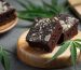 cannabis brownies and cannabis leaves put on wooden cutting board